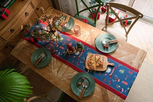 Detailed top view of a blue Christmas table runner with festive snowman and elk patterns