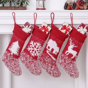 Set of 4 red knitted Christmas stockings with reindeer tree patterns and gift boxes
