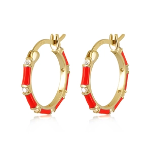 Macro shot of bamboo-shaped gold earrings with red enamel and inlaid white zircons