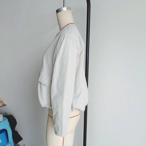 Detailed side view of beige outdoor flight jacket featuring large utility side pockets