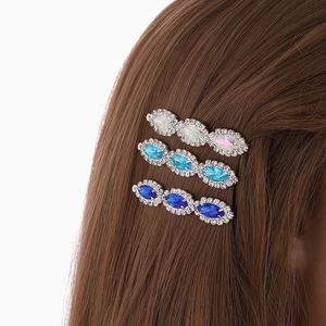 Three elegant crystal rhinestone hair clips in blue and iridescent on a model
