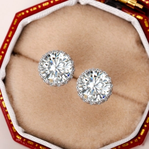 Detail of round cut crown zircon earrings in a premium red gift box padding