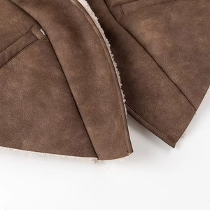 Detailed close-up of brown suede exterior with thick white faux shearling lining and stitching