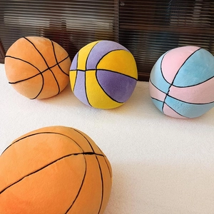 Detailed view of colorful plush basketball pillows on a white rug in a cozy room