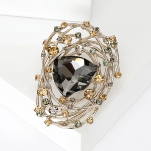 Detail of vintage bird nest brooch with dark grey triangular stone and yellow rhinestones