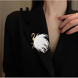 Detail of elegant swan brooch with soft white feathers on a black suit lapel