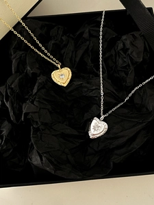 Detailed view of gold and silver heart pendants with star patterns on black silk