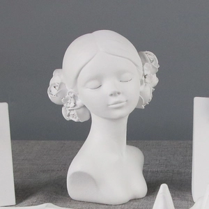 Detail shot of a white resin girl bust sculpture featuring delicate flower hair ornaments