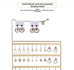 Detailed view of golden iron jewelry stand with multiple tiers and wooden base