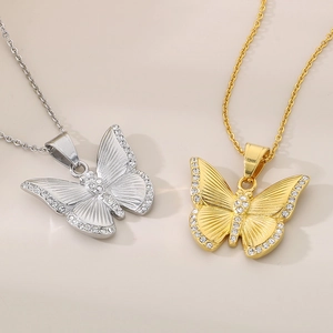 Close-up of gold and silver butterfly necklaces with sparkling diamond inlay detail