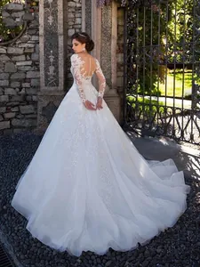 Elegant long sleeve lace wedding dress featuring a detailed open back and grand train