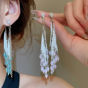 Vue détaillée des boucles d'oreilles à pompons goutte d'eau avec strass en bleu et violet