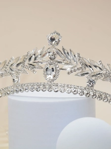 Detailed view of silver leaf bridal crown with sparkling rhinestones on display stand