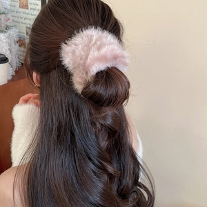 Dettaglio dell'elastico per capelli in peluche rosa con consistenza morbida e vellutata
