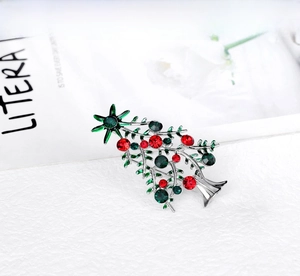 Macro shot of silver alloy Christmas tree brooch with red and green rhinestones