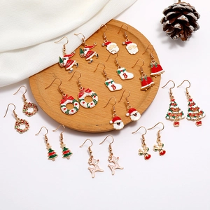 Christmas alloy earrings set featuring Santa, reindeer, and snowflakes on a wooden tray