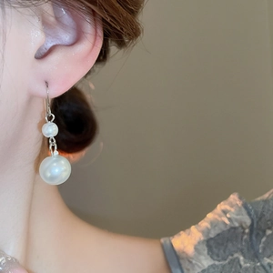 Detailed close-up of French vintage drop earrings with double pearls and silver chain
