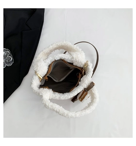 Top view of white faux shearling bucket bag showing gray fabric lining and inner pockets