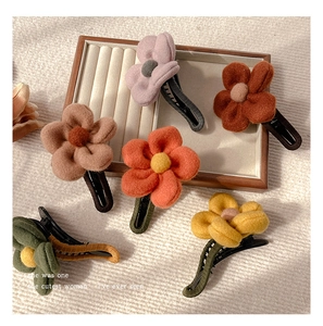 Close-up of fabric flower hair clips with soft felt texture and autumn-toned colors