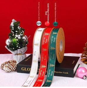 Close-up of Merry Christmas gold-edged satin ribbons with festive tree patterns