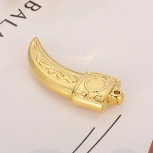 Ciondolo a dente di lupo dorato con rilievo floreale decorativo su sfondo chiaro