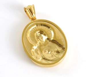 Detailed close-up of oval gold pendant with religious relief carving on polished steel
