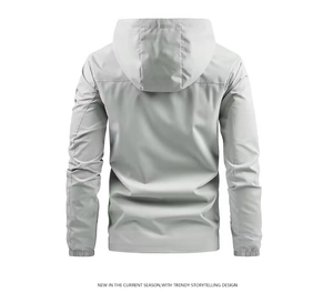 Detail view of the back of a light grey windproof jacket with a hood and elastic cuffs