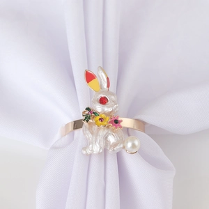 Golden flower bunny napkin ring with white enamel rabbit and pearl detail on white cloth