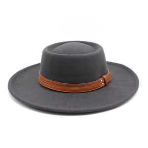 Detailed texture of dark grey wool felt hat with brown leather band and silver buckles