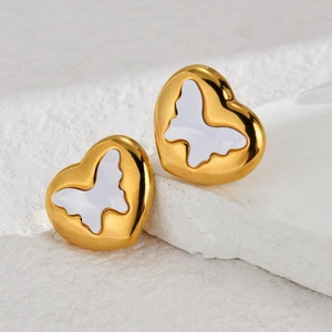 Elegant gold heart earrings with white mother-of-pearl butterfly inlay on stone background