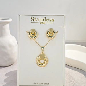 Detail of gold woven rope knot necklace and earrings set on white display card