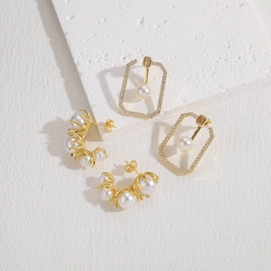 Detail of 14K gold plated geometric earrings with pearls and shimmering zircons