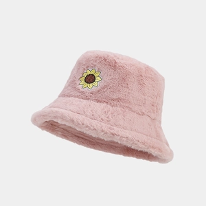 Detail of pink plush bucket hat with soft faux fur texture and sunflower patch