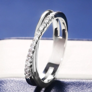 Vue macro d'une bague croisée argentée avec zircons sertis main dans un écrin à bijoux