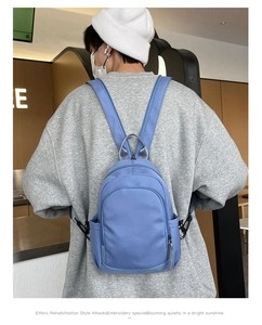 Gedetailleerd overzicht van de blauwe nylon casual rugzak, met fraaie stof en handige zakken.