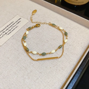 Detail of double-layer gold plated bracelet with green beads in a jewelry box