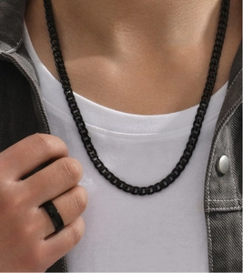 Close-up of a men's black stainless steel cuban chain necklace and matching band ring