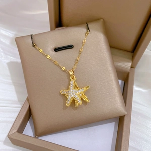 Starfish gold necklace with pearls and pavé diamonds on a satin background