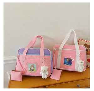 Detail of JK style ita bag with transparent heart window and plush bear charm accessory