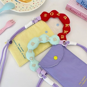 Détails des mini sacs en toile avec bandoulières brodées et lettrage artistique