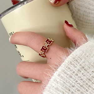 Detail of 18K gold plated H-letter ring with red enamel inlay and zircon accents