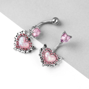 Detailed view of silver belly rings featuring pink heart-shaped crystals and zircon accents