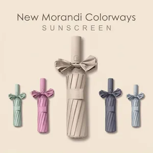 Vue détaillée de parasols pliants aux couleurs Morandi avec rubans décoratifs élégants