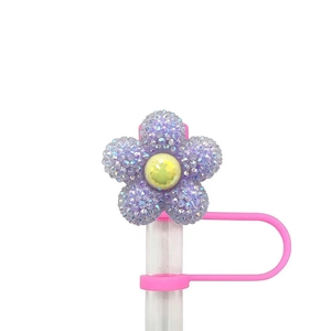 Detail of purple glitter flower straw topper with yellow center on a pink holder cap