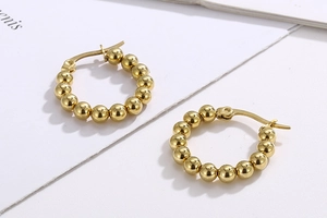 Detailed close-up of French style gold beaded hoop earrings with high polish finish