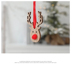 Close-up of minimalist wooden reindeer ornament with red pom-pom nose and festive silk ribbon