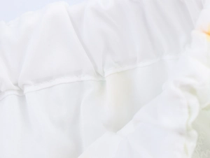 Dettaglio ravvicinato della trama del tessuto bianco e della cucitura elastica in vita