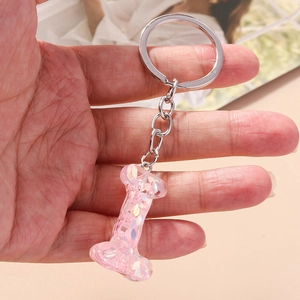 Pink glitter resin alphabet L keychain with silver metal ring held in hand