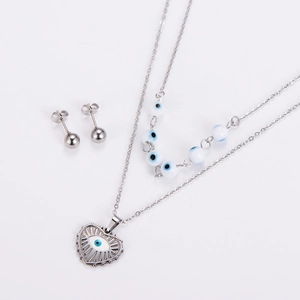 Detail shot of heart-shaped evil eye pendant and matching stud earrings jewelry set