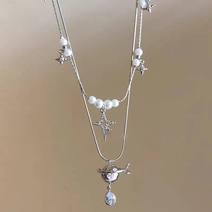 Silver double layer pearl necklace with star and Saturn pendant featuring pear cut zircon